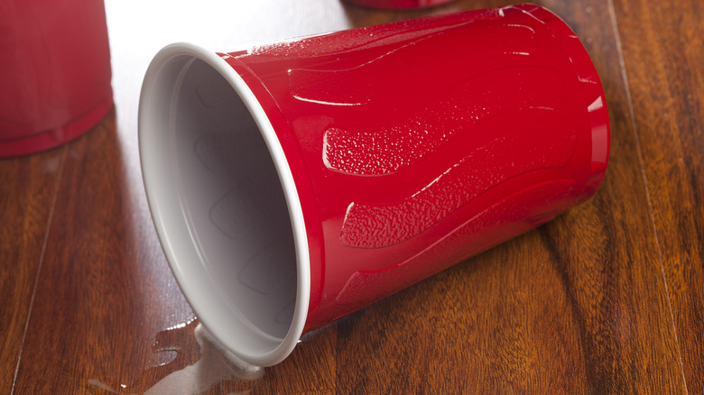 overturned red solo cup with beer