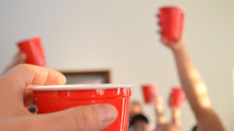 frat party hand lifting a cup