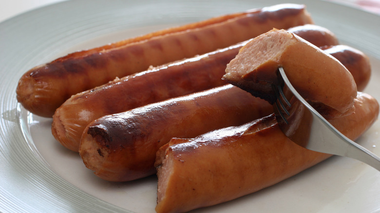 hot dogs on plate with piece on fork