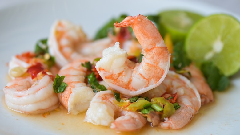 shrimp ceviche with lime wedges on plate