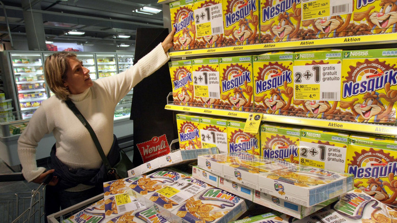 Shopper grabbing box of Nesquik Cereal from French store