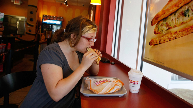 woman eating breakfast sandwich