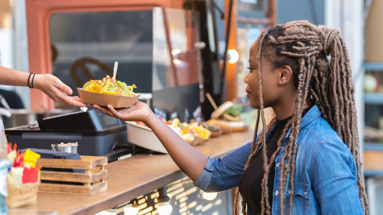 Someone hands a customer food