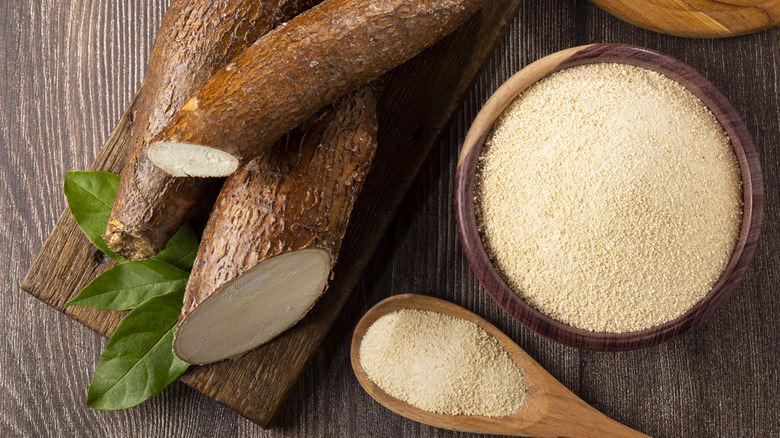 bowl of tapioca flour and several cassava roots cut to show their white insides