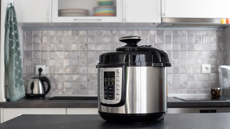 Silver pressure cooker on a kitchen counter