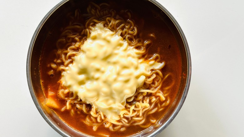 Ramen in pot with a cheese slice melted on top