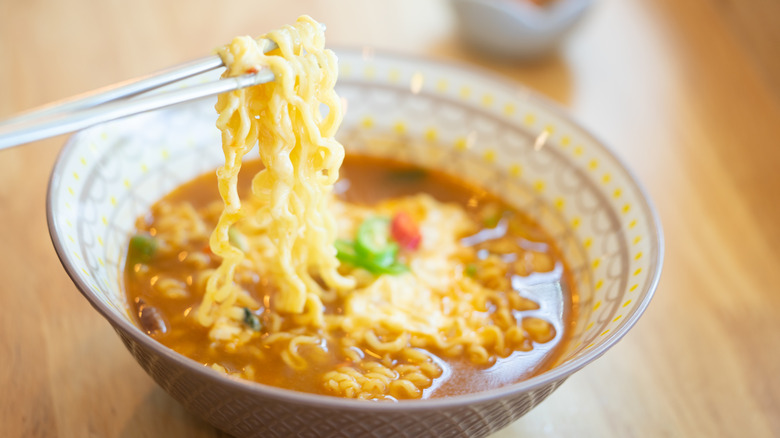 chopsticks raising ramen noodles out of bowl