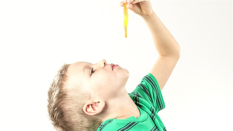 Boy about to eat gummy worm