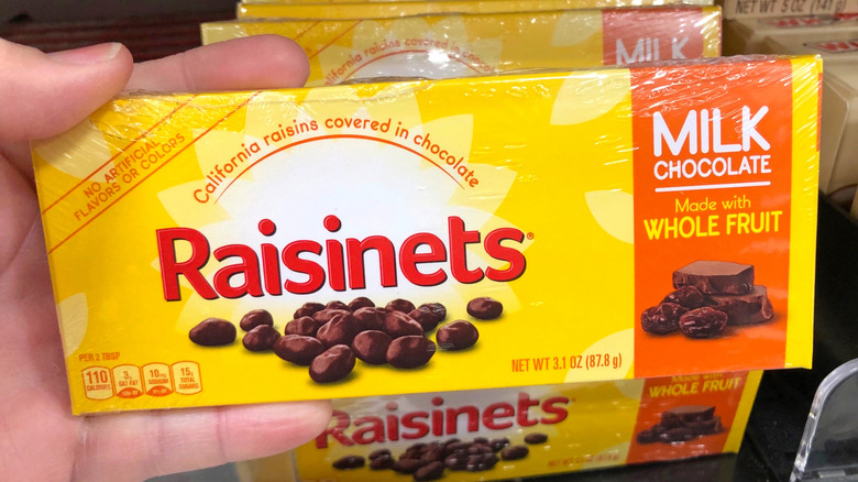 Person holding box of Raisinets