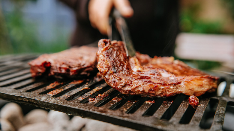 Person grilling meat outdoors