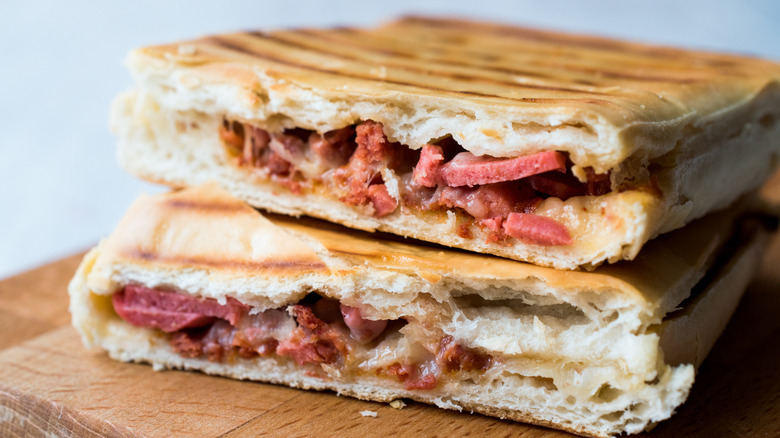 Leftover slices of pizza pressed together to make a panini and cut in half