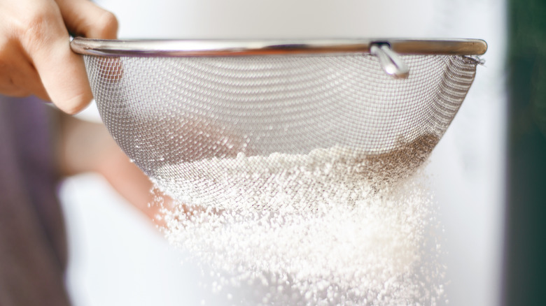 Person sifting flour