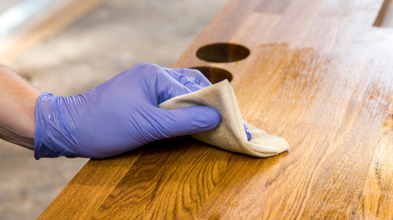 Person oiling wooden countertop 