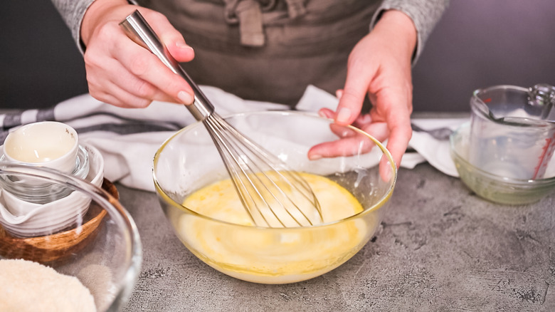 stirring cornbread ingredients in bowl on counter