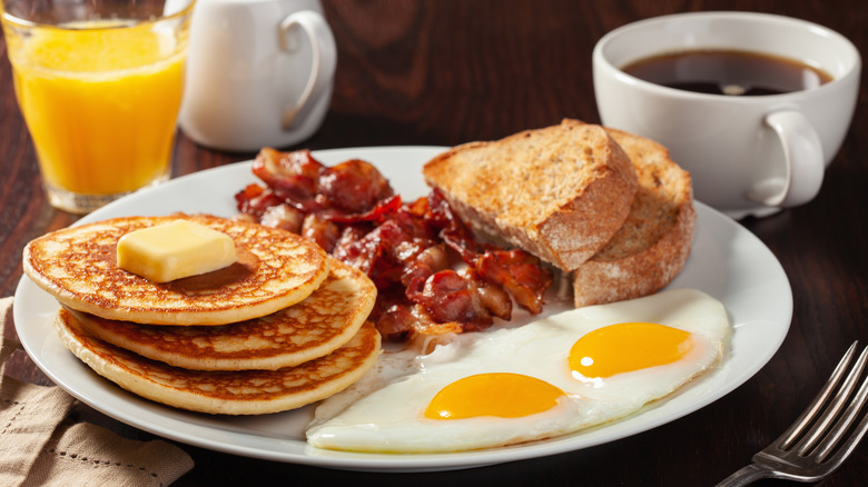 Bacon and pancakes on white plate