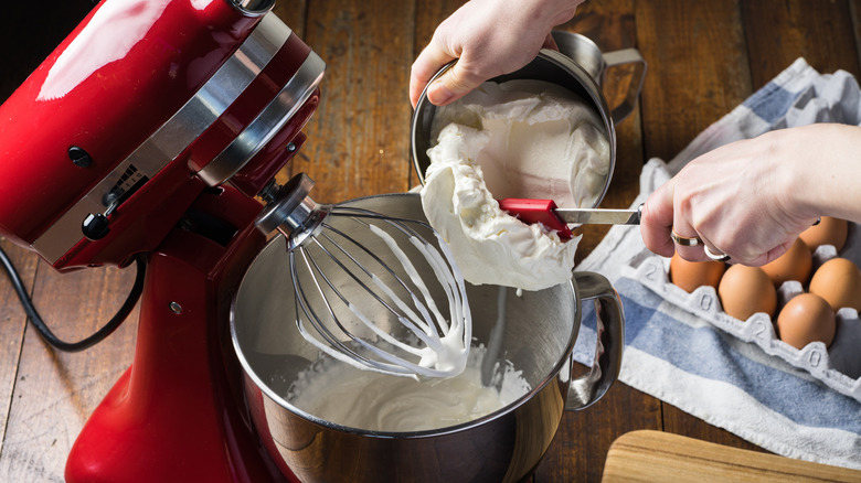 Person adding whipped cream to stand mixer 