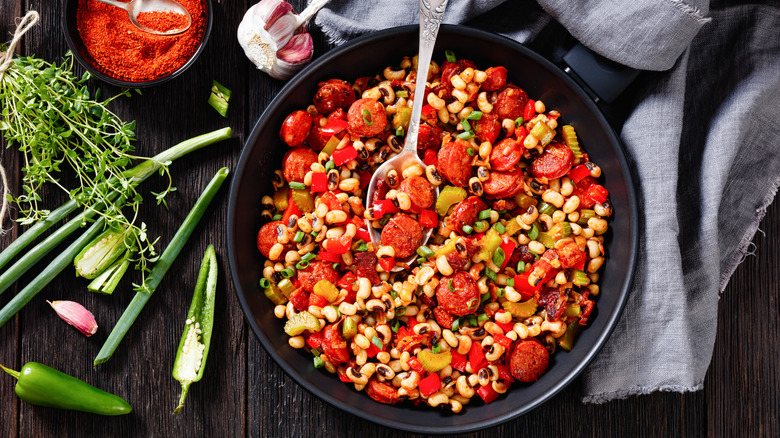 A bowl of Hoppin' John next to its ingredients