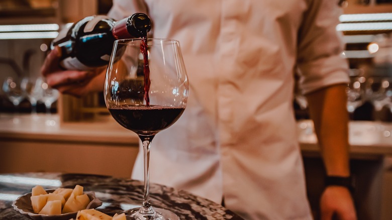 Server pouring red wine