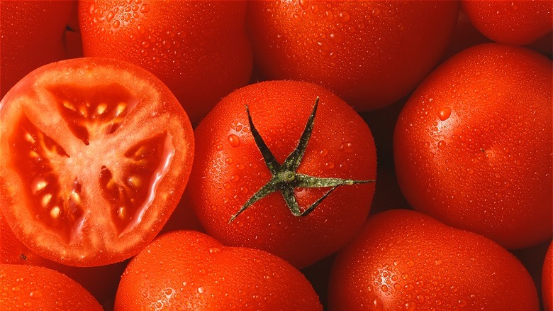 Fresh whole tomatoes with one halved