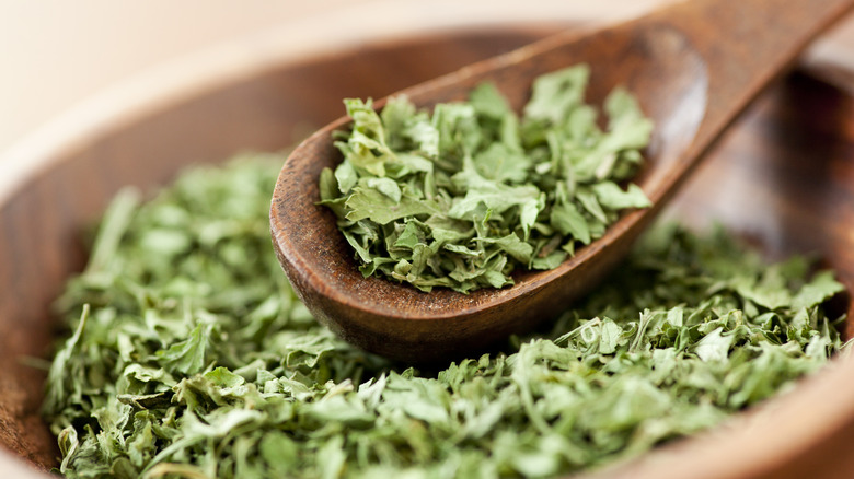 Dried parsley in bowl with wood spoon