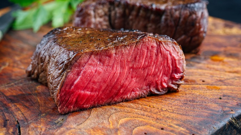 seared bison steak cut on a board