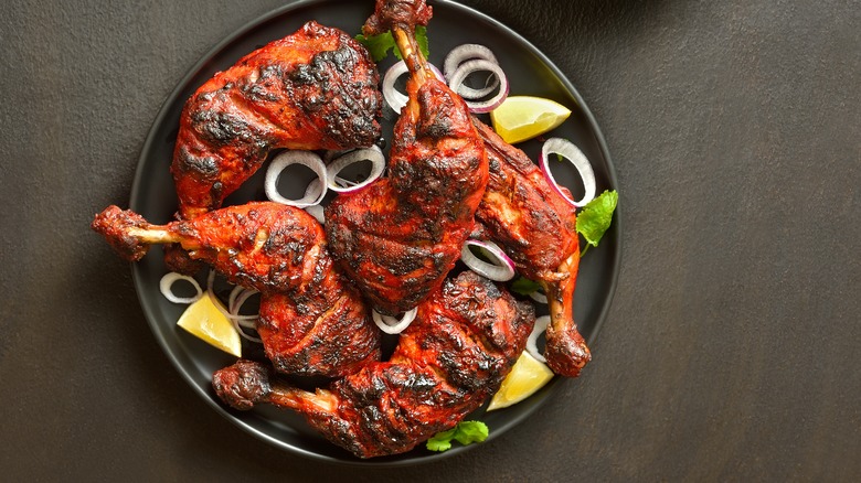 Tandoori chicken surrounded by onions and lemon