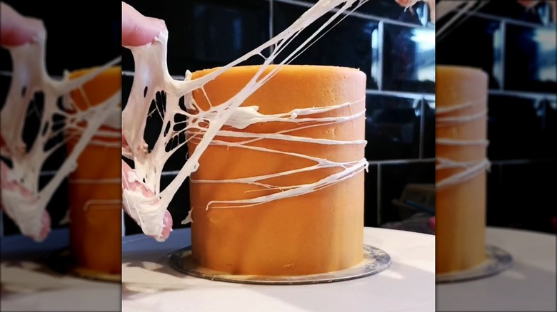 Covering cake in marshmallow spiderweb