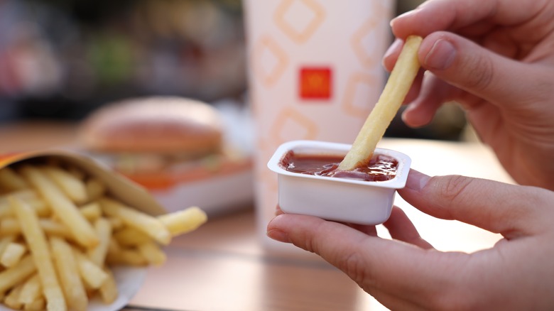 dipping fries into sauce