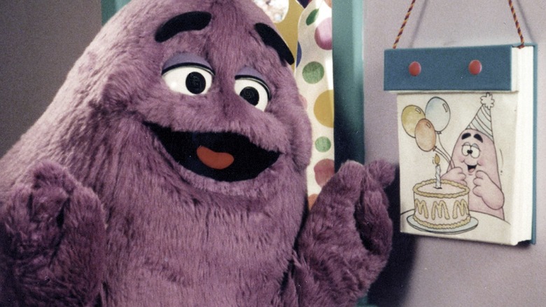 Grimace smiling next to picture