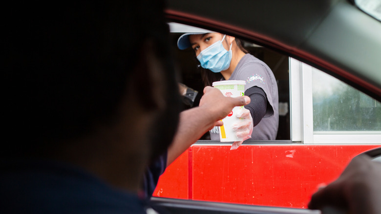 McDonald's employee hands customer a drink