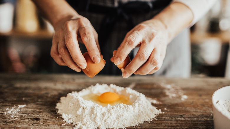 homemade pasta dough egg cracked in flour mound