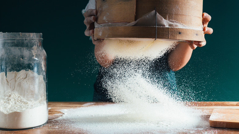 old fashioned flour sieve with glass jar of flour