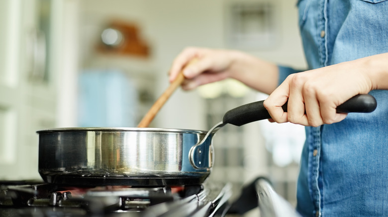 person stirring pot