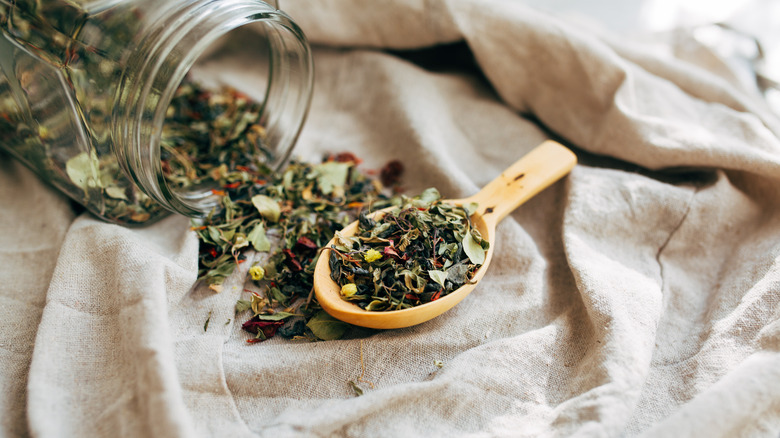 dried herbs in glass jar with spoon