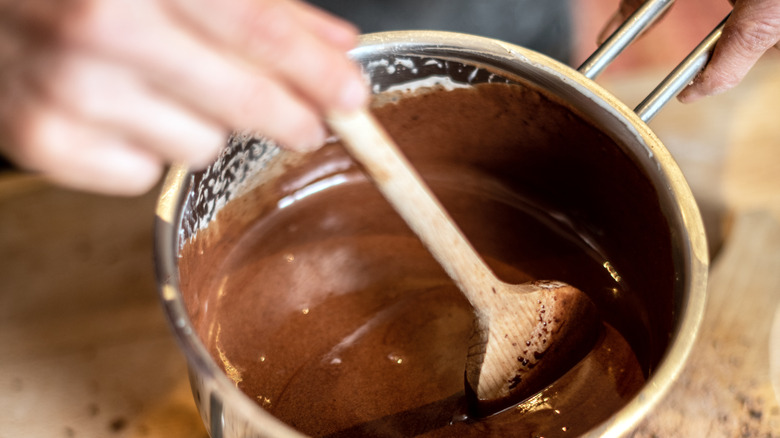 Person stirring a pot of melted chocolate