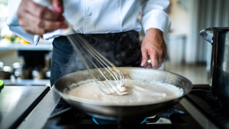 Whisking cream sauce in a pan