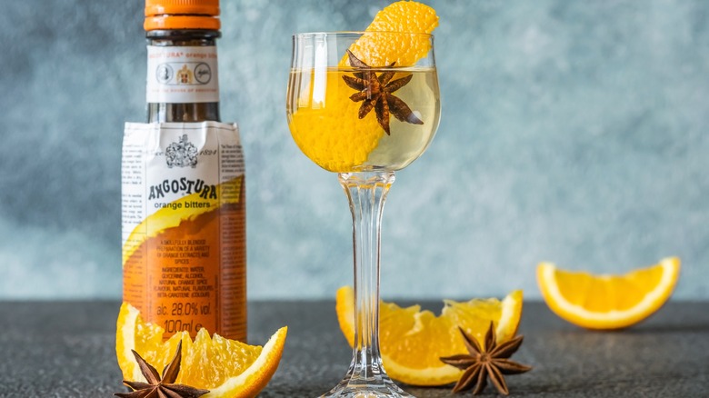 Cocktail next to bottle of Angostura orange bitters