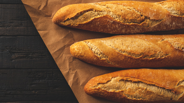 three baguettes on brown paper