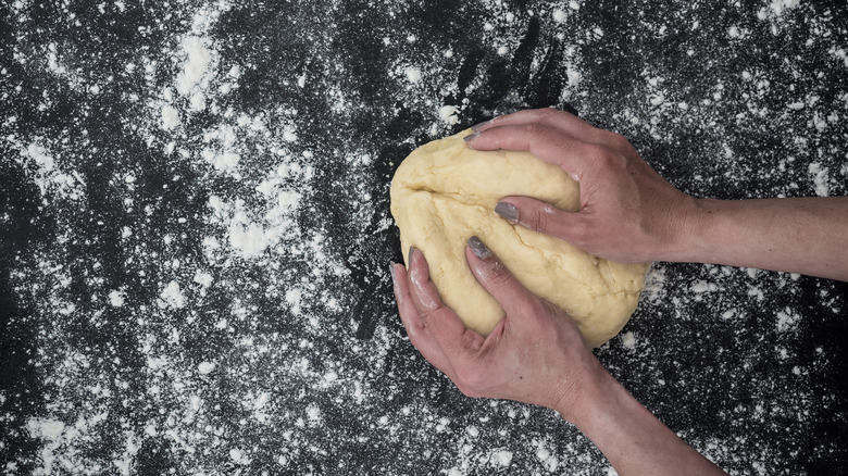 person kneading scone dough