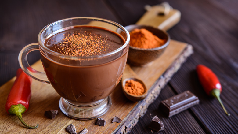 Hot chocolate in a glass mug topped with cayenne pepper