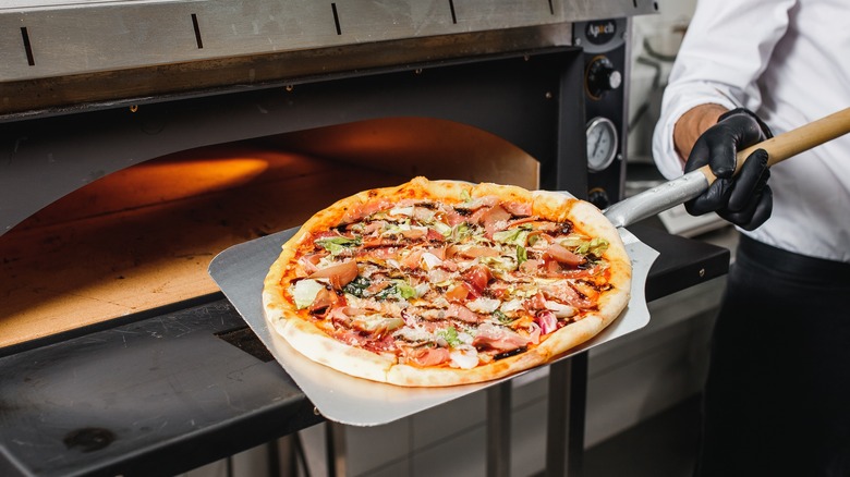 Pizza being taken out of an electric oven 