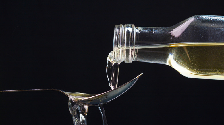 apple cider vinegar being poured over a spoon