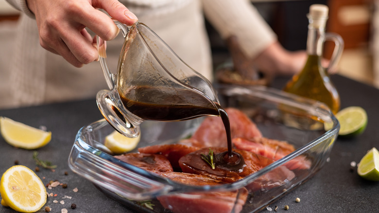 chef pouring marinade over cuts of meat