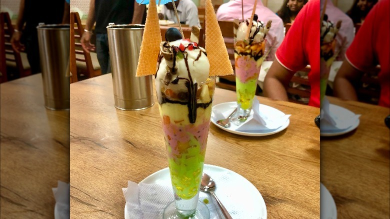 Falooda topped with cookies in tall glass