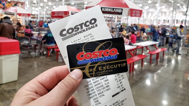 person holding a Costco membership card in a store