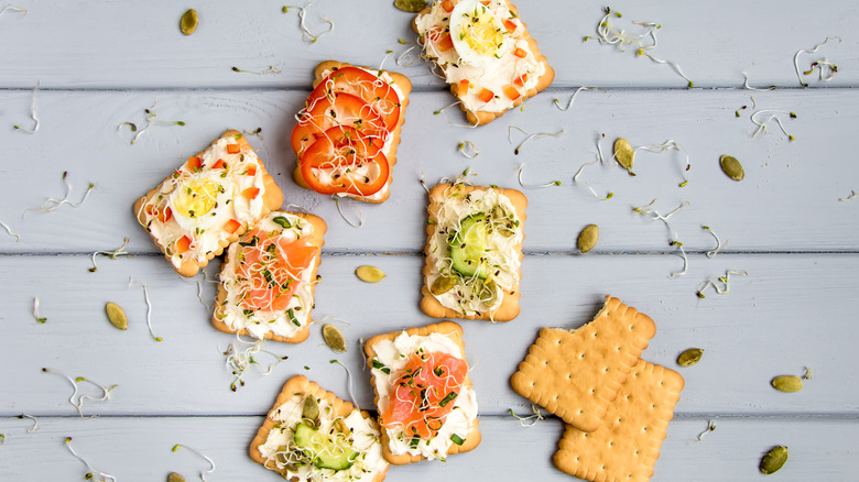 crackers with cream cheese and vegetable toppings