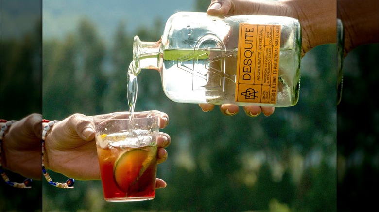 pouring aguardiente in glass