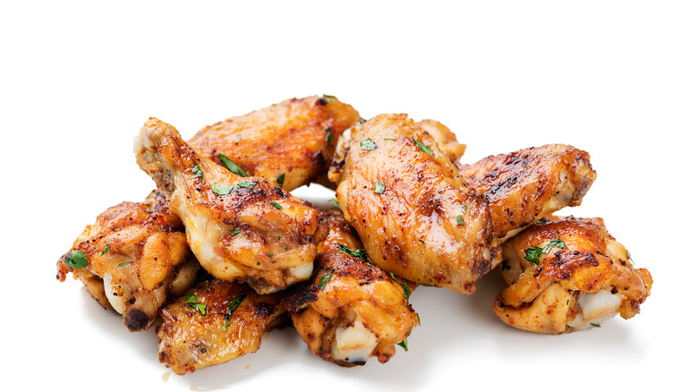 cooked chicken wings sauced herbs white background