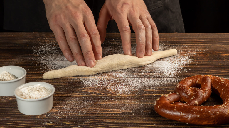 Person rolling out pretzel dough