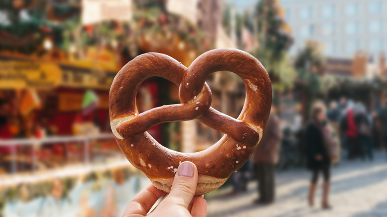 Hand holding pretzel in a holiday market